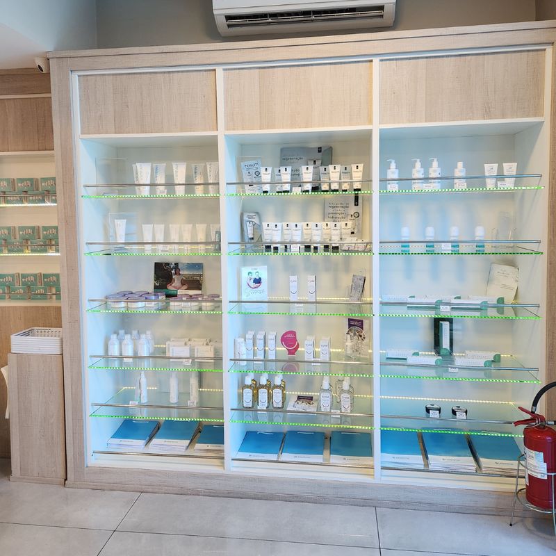 Expositor iluminado da Easyfarma com dermocosméticos organizados em prateleiras de vidro.