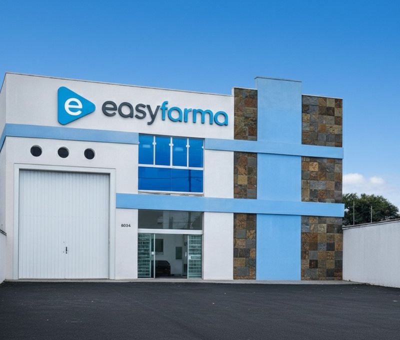 Fachada da matriz da Easyfarma em Curitiba: prédio de dois andares, branco e azul, com o logotipo no alto.
